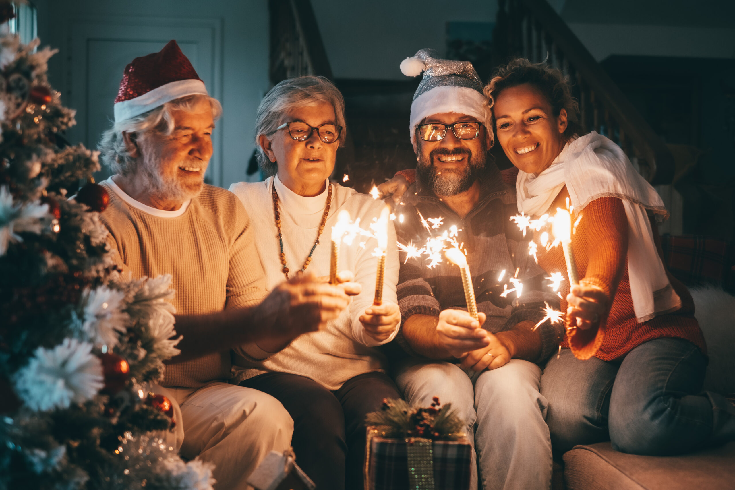 Happy family group of senior parents and middle aged son with wife celebrating Christmas holidays and new year together at home. Happy lifestyle for mature retirees, party lights